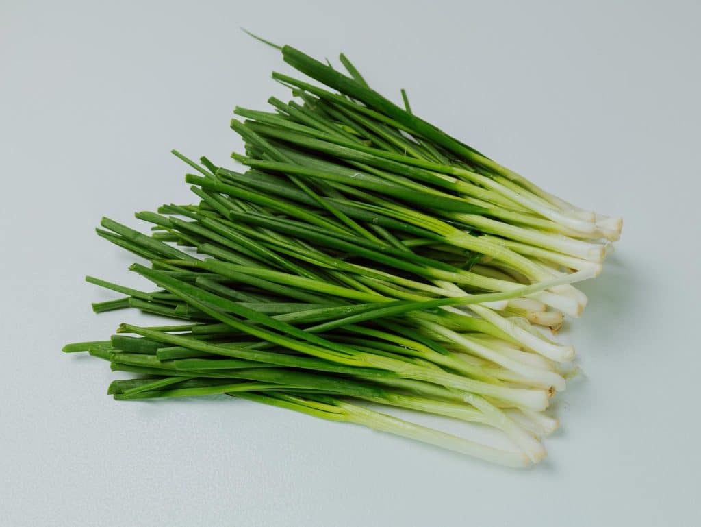 Chives, an onion family member, are slender green herbs known for their delicate and mild onion-like flavor. 