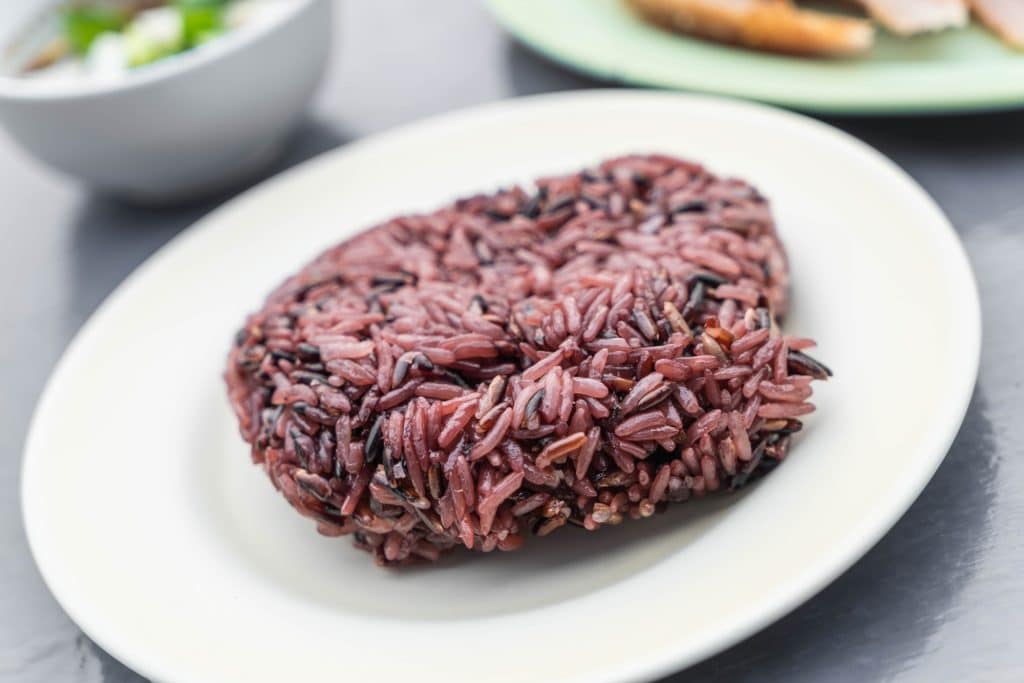 Red yeast rice is obtained by growing red yeast (Monascus purpureus) on cooked white rice kernels. The fermented rice appears reddish-purple due to yeast's pigmentation capability.